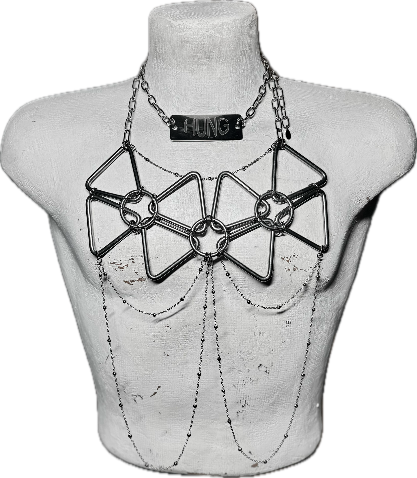 A stainless steel body harness featuring geometric web-like shapes connected by rings and draping chains. The harness is worn over the chest, designed by Hung by Danny.