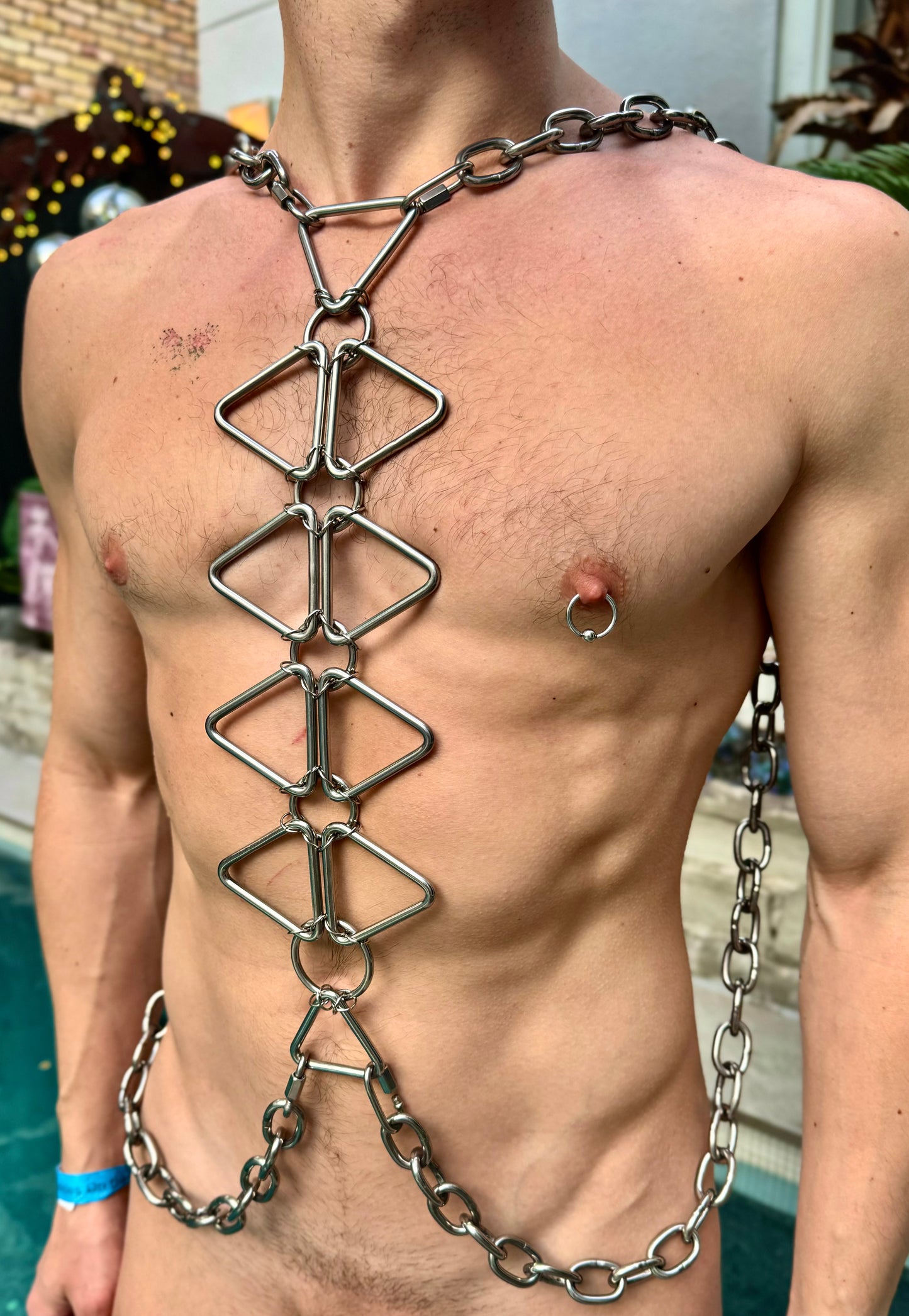 Stainless steel body chain made up of triangle, rings, and a thick chain on a man’s body